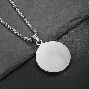 Macro shot of silver brushed titanium pendant with durable box chain detail