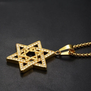 Dettaglio della collana con ciondolo a esagramma dorato e zirconi su pelle nera di lusso