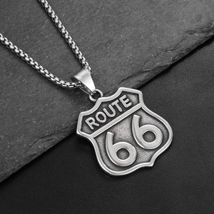 Detail of vintage Route 66 shield pendant with brushed texture on grey stone