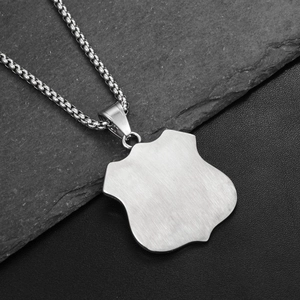 Detail view of blank brushed stainless steel shield pendant with high-end box chain