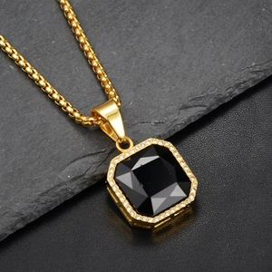 Dettaglio catena box oro hip hop e pendente con gemma nera ottagonale e diamanti halo