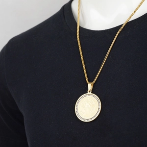 Hip hop gold Saint Benedict medal necklace with sparkling crystals on black T-shirt