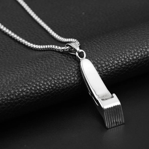 Detailaufnahme des silbernen Haarschneider-Anhängers aus poliertem Titanstahl