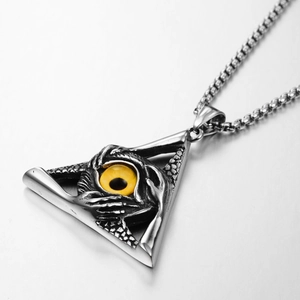Macro shot of vintage stainless steel triangle pendant with a yellow glass eye detail