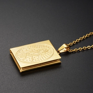 Macro shot of gold Virgin Mary book locket pendant with intricate engraved details