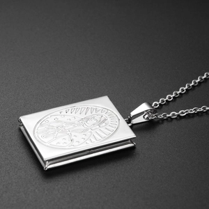 Detailed macro of openable silver locket necklace with Virgin Mary religious engraving