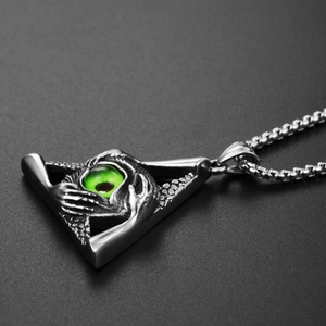 Macro shot of hip-hop triangle eye pendant with green glass bead and carved hands