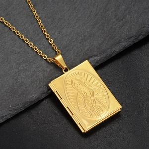 Detail of a golden locket necklace featuring a religious Virgin Mary relief on book pendant
