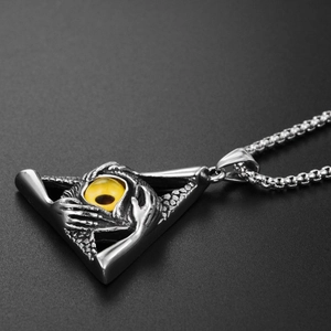 Macro detail of gothic triangle all-seeing eye pendant with yellow glass eyeball