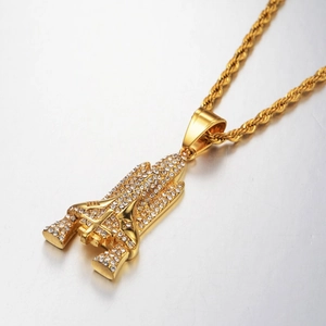 Macro view of gold-plated rocket pendant with 18K engraving and pavé set white crystals