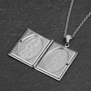 Hip hop saint mary locket necklace in stainless steel on a dark stone background