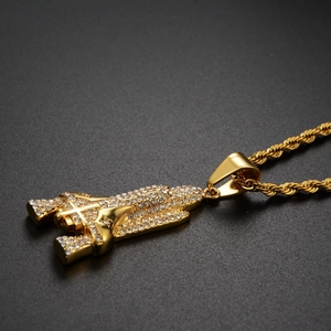 Detailed view of hip hop rocket pendant with sparkling rhinestones and gold rope chain