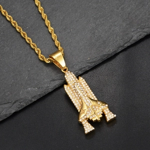 Macro shot of gold iced out space shuttle pendant with glistening clear zircon stones
