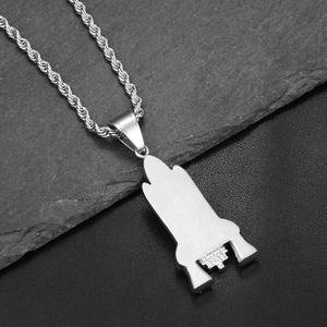 Detailed macro of silver rocket pendant with white diamond accents on rope chain