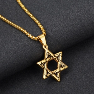 Detail eines goldenen hohlen Hexagramm-Anhängers mit schwarzen Gravuren an Boxkette