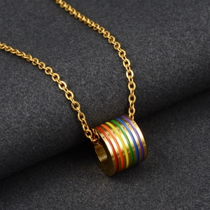 Vue macro du pendentif cylindre doré avec des bandes d'émail arc-en-ciel à six couleurs
