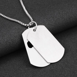 Detail of silver brushed titanium steel double dog tag pendant and bead chain