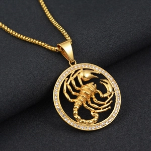 Gros plan détaillé du pendentif scorpion doré avec strass blancs sur une chaîne gourmette