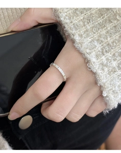 Close-up of minimalist silver heart shaped open ring worn for daily stackable styling