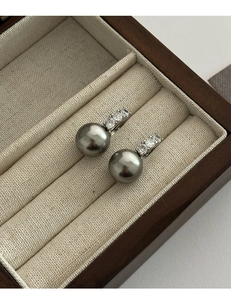 Vue macro de boucles d'oreilles perles grises avec oxydes de zirconium sur coffret
