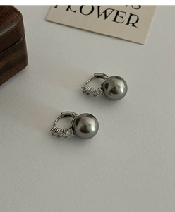 Détail de boucles d'oreilles perles gris foncé avec métal argenté et pierres zircons