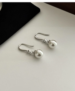 Detail of silver pearl drop earrings featuring micro-pave crystals and elegant luster