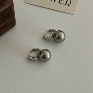 Boucles d'oreilles perles grises avec accents en zircon argenté sur fond texturé ivoire