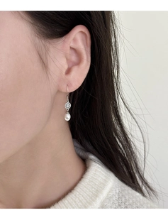 Dettaglio dei ganci per orecchini in argento vintage con motivo e perla a goccia bianca