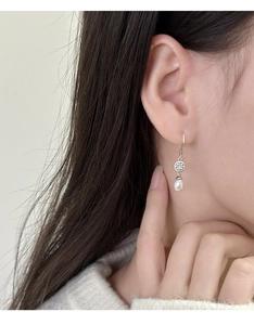 Dettaglio ravvicinato degli orecchini di perle a goccia con elegante filigrana d'argento