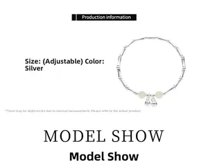 Detail showing adjustable silver bamboo style bracelet with green beads and small bells