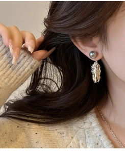 Gros plan détaillé des boucles d'oreilles perles grises avec pampilles argentées