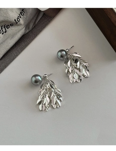 Détail macro de boucles d'oreilles à pampilles avec perle gris foncé et feuilles argent