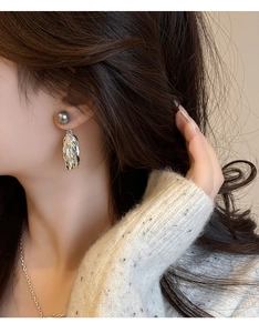 Gros plan d'élégantes boucles d'oreilles à pampilles argentées avec perles sur un mannequin