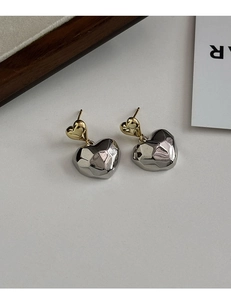 Détail de boucles d'oreilles double cœur minimalistes avec pendentif en argent à facettes