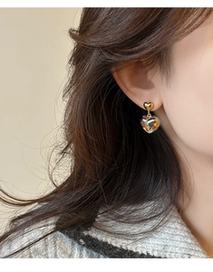 Gros plan de boucles d'oreilles cœurs minimalistes en finition bicolore or et argent