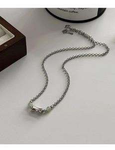 Close-up of vintage silver bamboo necklace with light green jade beads on a white surface