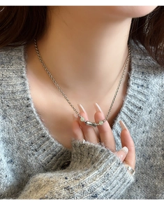 Detail view of Hetian jade bamboo pendant necklace worn on a grey knit cardigan