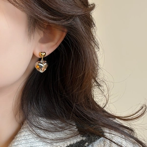 Boucles d'oreilles cœur bicolores avec pendentifs argentés facettés sur mannequin