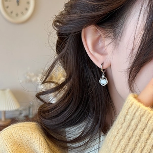 Boucles d'oreilles Ruyi en argent 925 avec pierre œil de chat portées par un mannequin