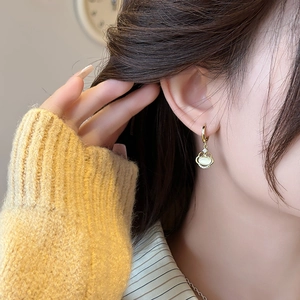 Élégantes boucles d'oreilles Ruyi en or 18 carats avec pierre œil de chat sur un mannequin