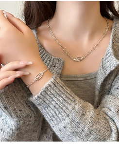 Gros plan d'un pendentif ovale doré avec gravure loveme sur un ensemble de bijoux