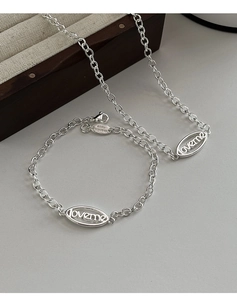 Détail du pendentif ovale LOVEME sur collier et bracelet en argent poli brillant