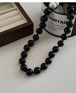 Detailopname van de kralenketting met zwarte onyx kralen en witte turkoois steen