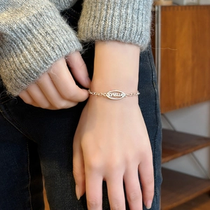 Bracelet chaîne en argent élégant avec breloque ovale LOVEME porté par un mannequin