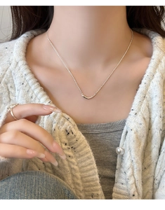 Gros plan du collier sourire en argent minimaliste et de la bague brillante sur le mannequin