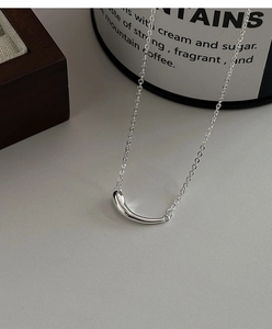 Détail macro du collier minimaliste en argent S925 avec pendentif goutte d'eau