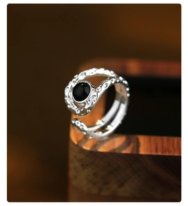 Macro detail of textured silver ring featuring hammer finish and black onyx stone inlay