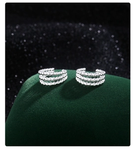 Vue détaillée du ear cuff argenté à trois couches sur présentoir en velours vert