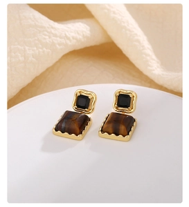 Detailed view of French vintage square earrings with tiger eye stone and gold wavy metal