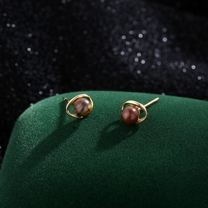 Boucles d'oreilles rétro en œil de tigre avec anneaux de Saturne dorés sur velours